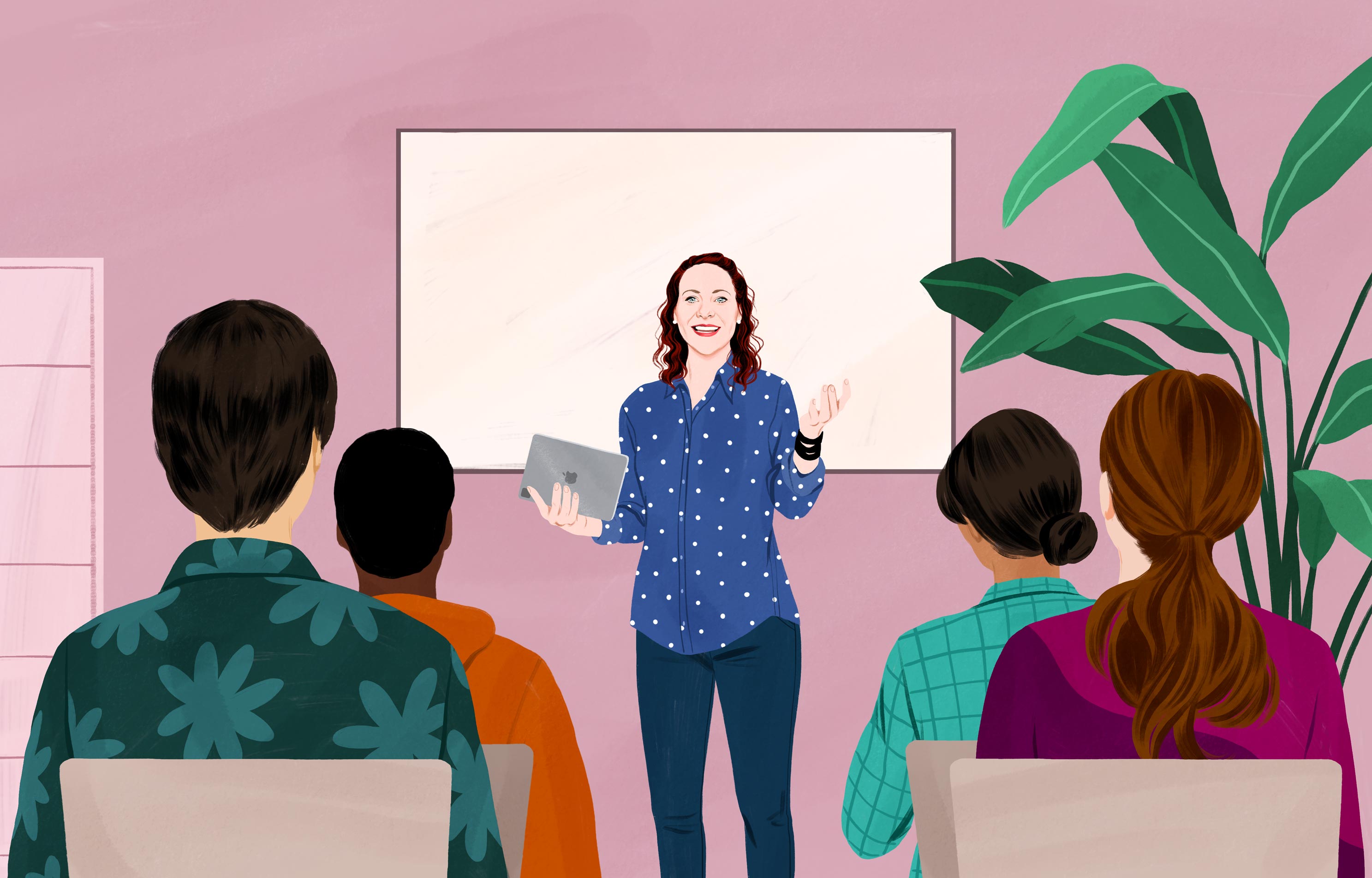 Jessica smiling and holding an iPad, standing in front of a group of adults, gesturing as if explaining.