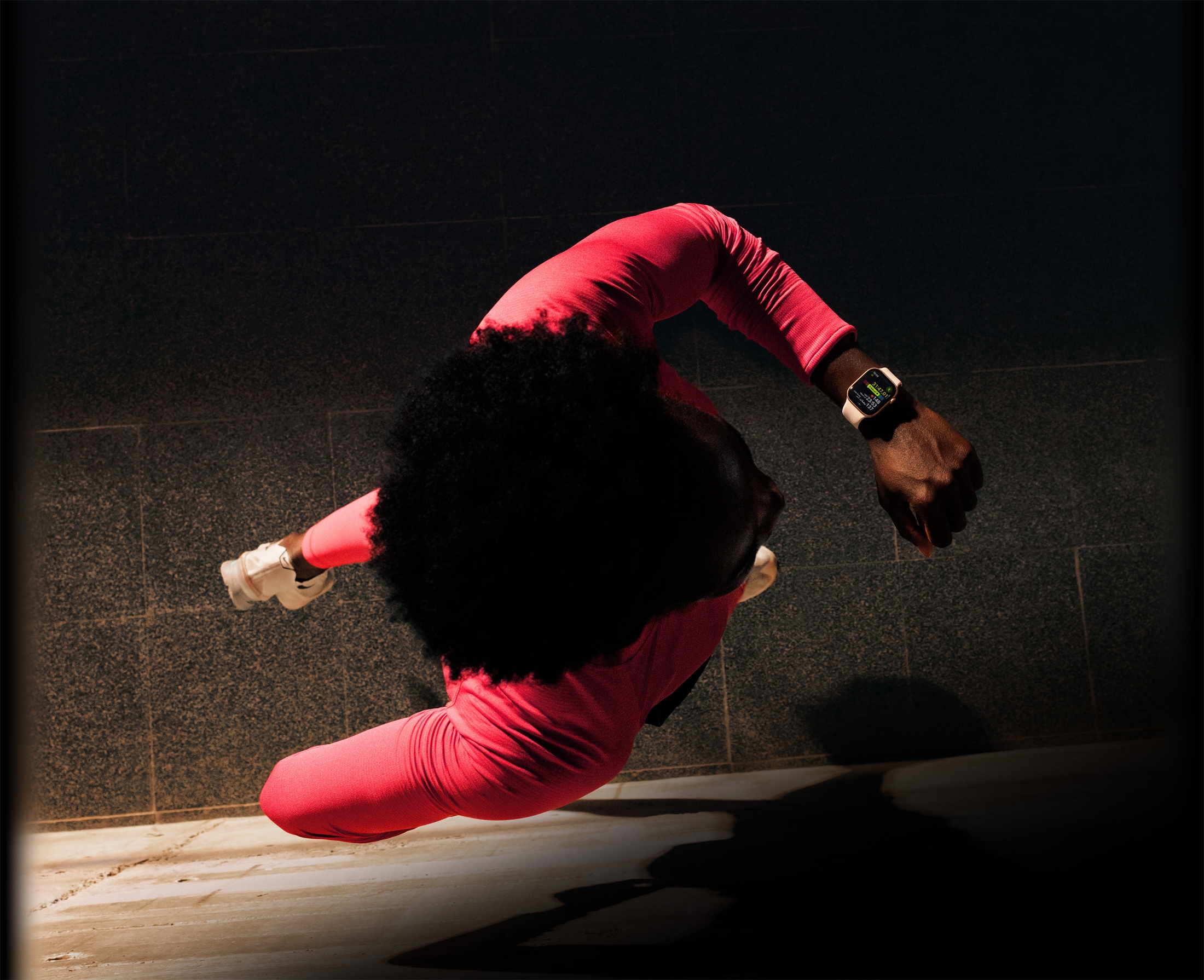 شخص يركض ويتحقق من التقدم في تطبيق التمرين على Apple Watch Series 11