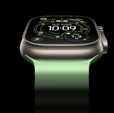 A close-up of a Natural Titanium Apple Watch Ultra 3 on a black background. The display shows the time and other dynamic info.