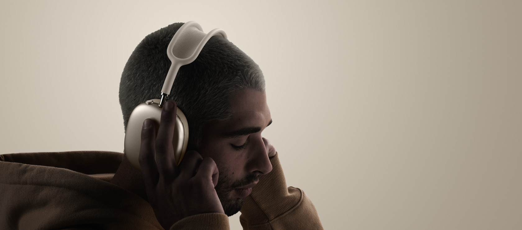 رجل يرتدي سماعات AirPods Max ويلمس بطانة الأذنين.