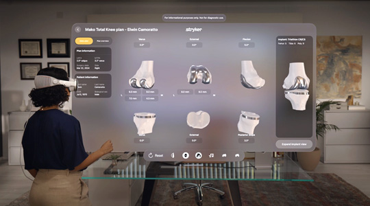 Une chirurgienne portant l’Apple Vision Pro interagit avec une projection 3D d’os et d’articulations du genou dotée de pièces métalliques