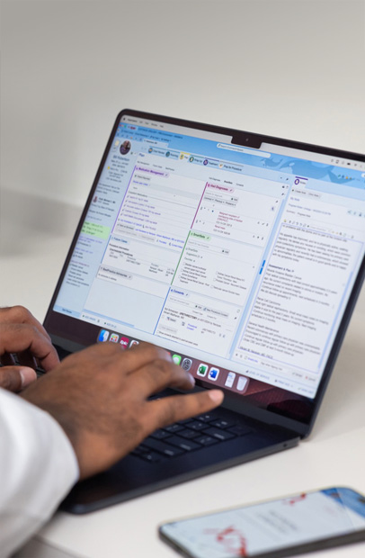 صورة لمقدم رعاية يتحقق من السجلات الصحية الإلكترونية على MacBook Pro.