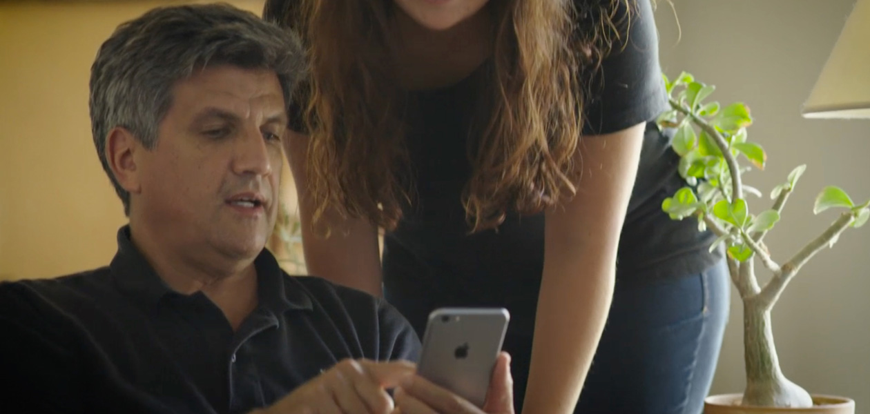 رجل يشارك معلوماته الصحية على iPhone مع سيدة تقف بجانبه.