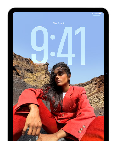 iPad showing Lock Screen where large numerals for the time appear behind the picture of a person sitting