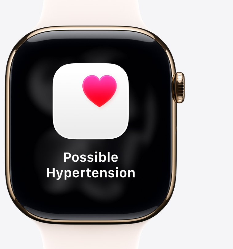 Apple Watch Series 11, hliníkové pouzdro, růžově zlatá barva, oznámení o možné hypertenzi, růžové srdce na bílém poli, na pravém boku korunka Digital Crown, světle ruměný sportovní řemínek